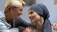 Mom supporting and hugging her daughter with cancer, visits in oncohospital.